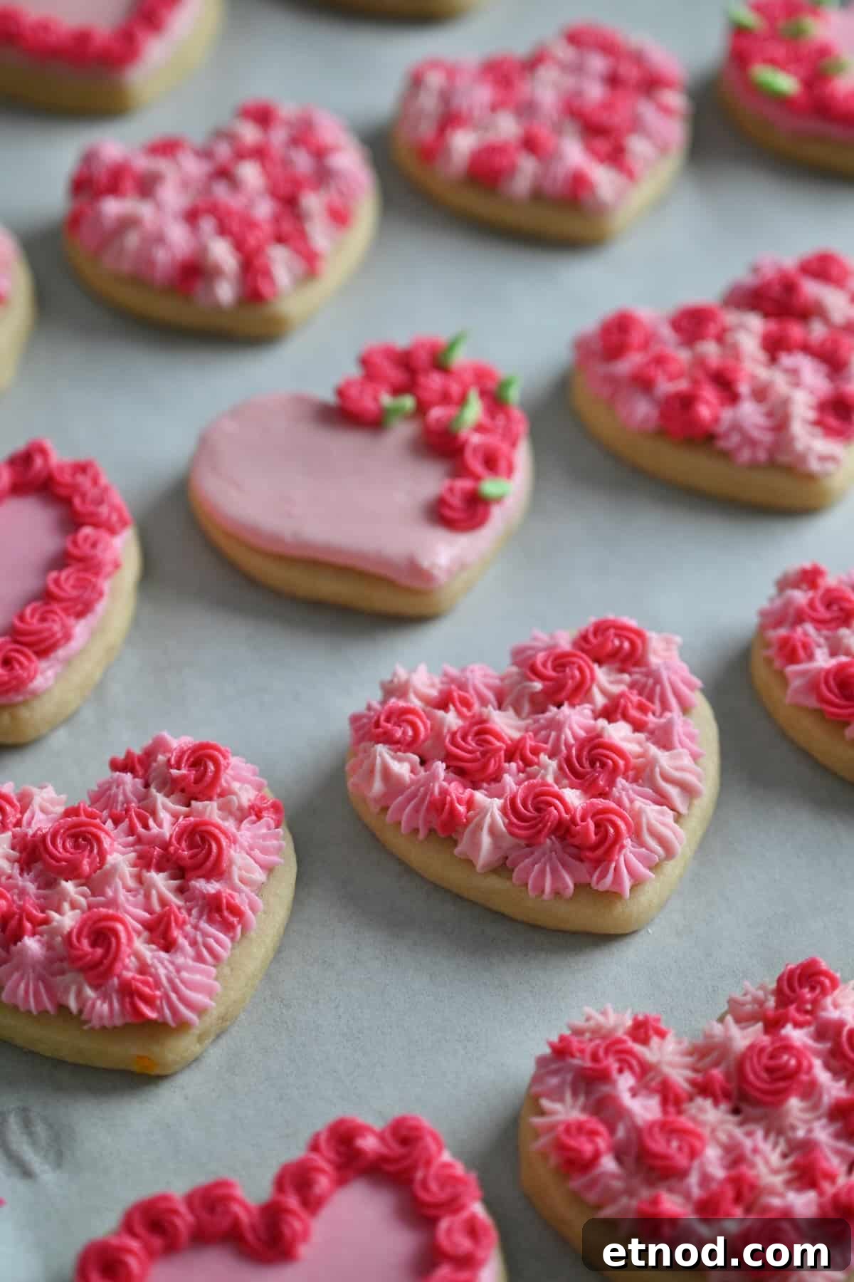 Valentine Sugar Cookies with Creamy Buttercream Frosting 2 A close up of soft heart sugar cookies with buttercream frosting designs in shades of pink.