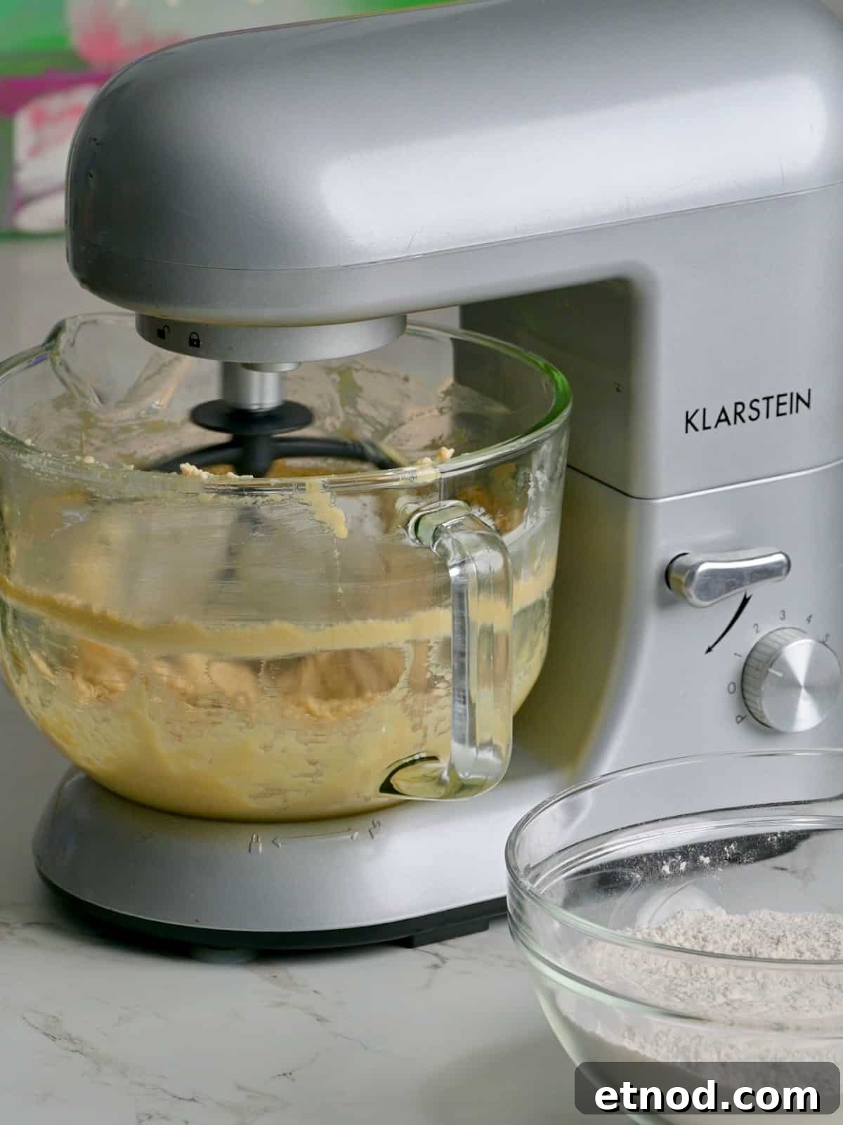 Valentine Sugar Cookies with Creamy Buttercream Frosting 5 Sugar cookie dough being made in a stand mixer, with dry ingredients in a bowl nearby.