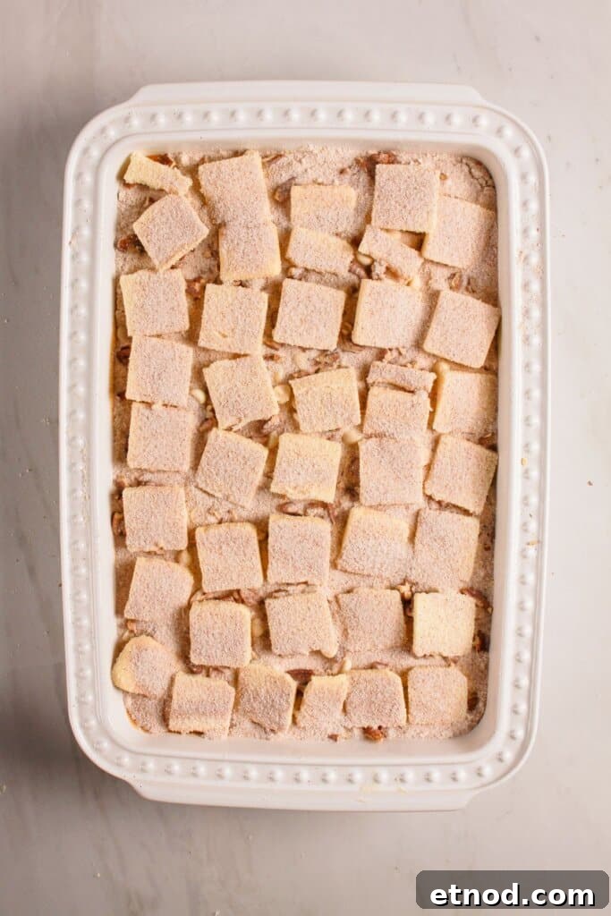 Pumpkin Pecan Dump Cake Recipe — Quick Fall Dessert with Pecans 10 Cinnamon sugar being sprinkled on top of a baking dish.