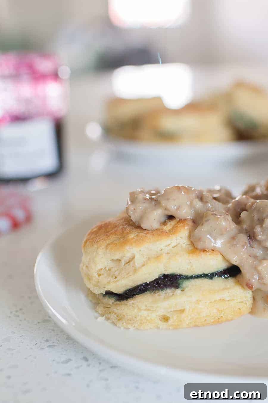 A plate with homemade biscuits and creamy sausage gravy on it.