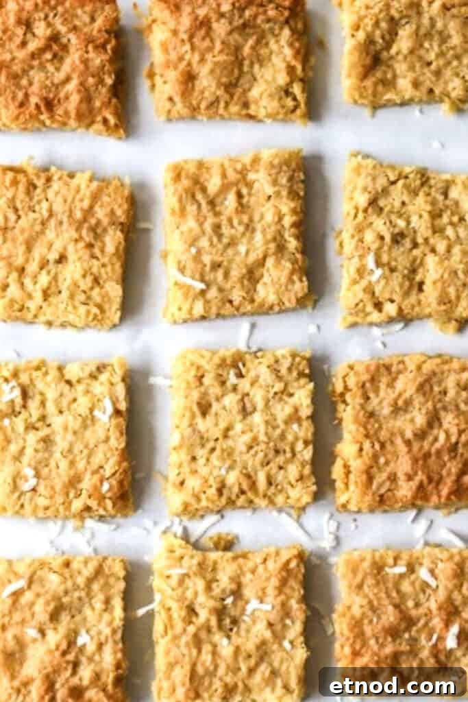 Chewy Coconut Cookie Bars Recipe for Summer Baking 3 Rows of coconut cookie bars cut into squares on a baking sheet.