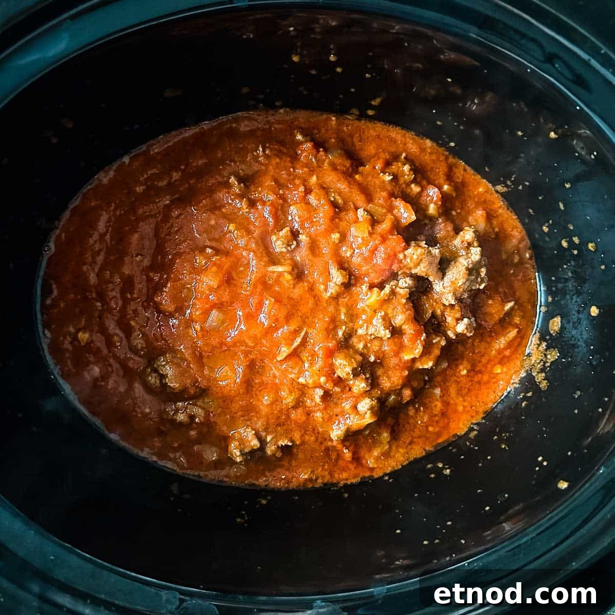 lamb ragu is transferred to a slow cooker.