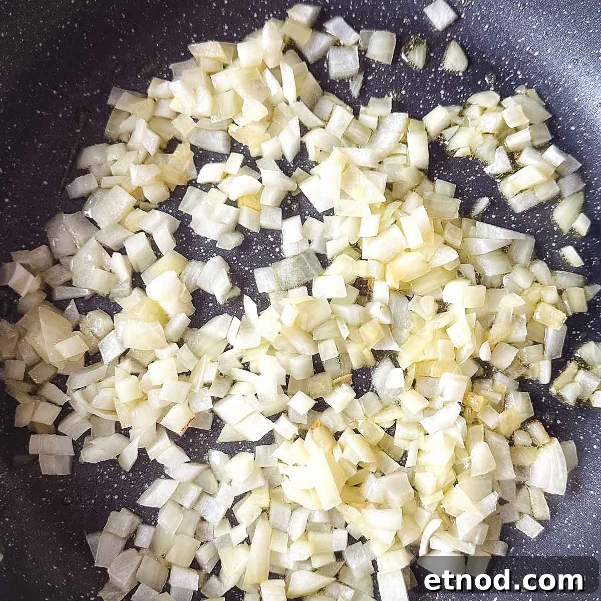 chopped onion sweating in a frying pan.