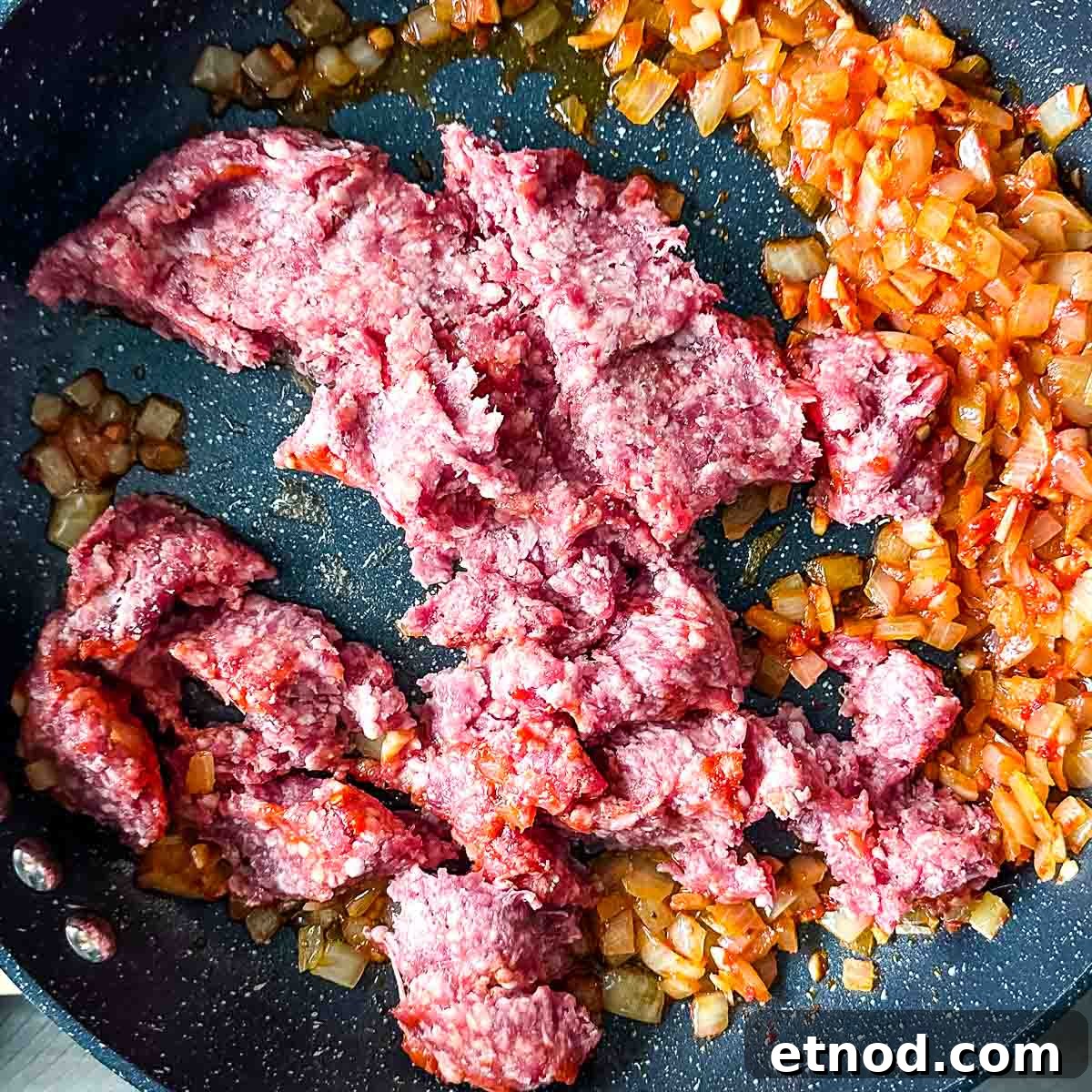 adding raw ground lamb to lamb ragu.