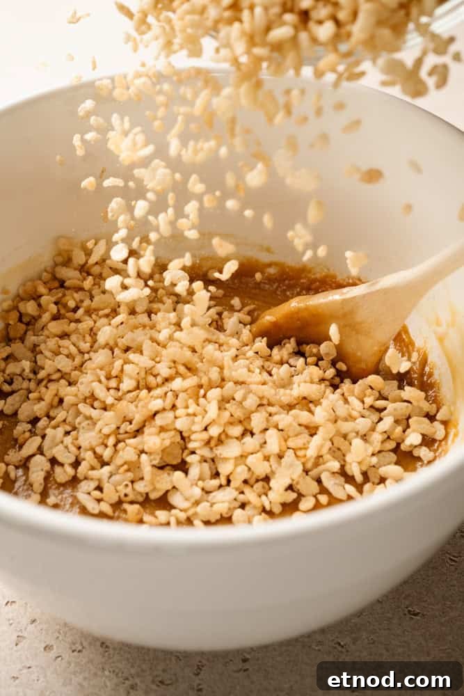 Cereal being poured into the peanut butter mixture.