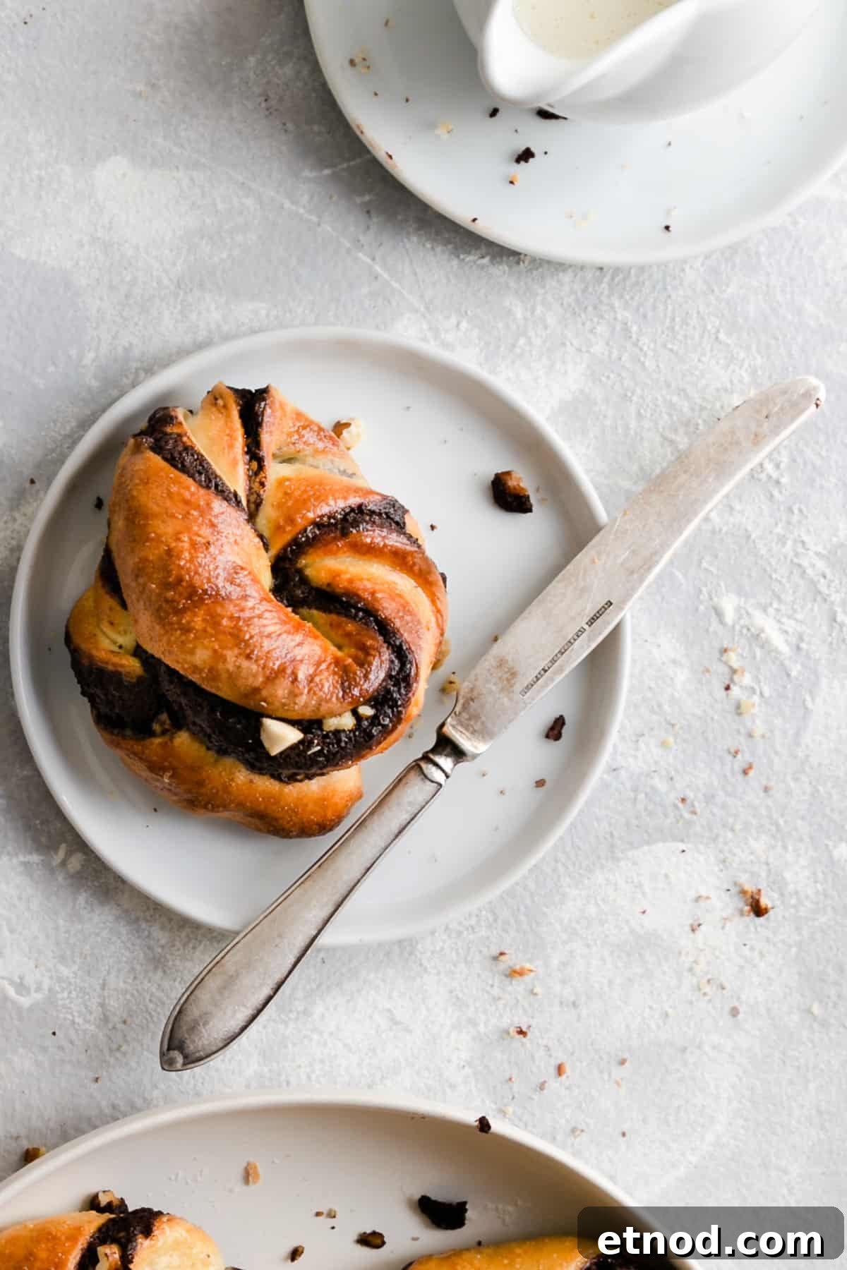 Chocolate Hazelnut Babka Buns Recipe with Gooey Swirls 3 overhead shot of a single chocolate hazelnut babka bun on a small white plate