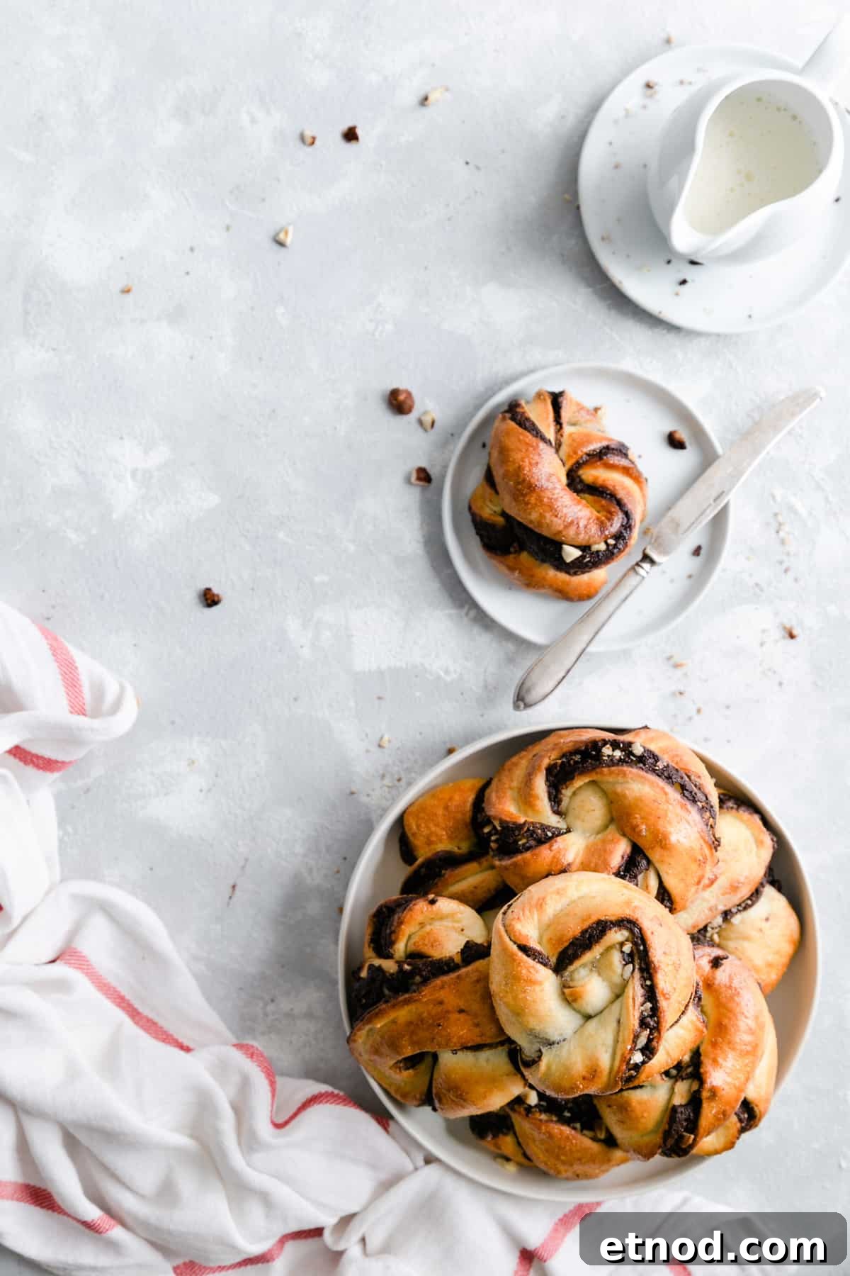 Chocolate Hazelnut Babka Buns Recipe with Gooey Swirls 10 Overhead shot of big plate filled with chocolate hazelnut babka buns and small plate with one bun