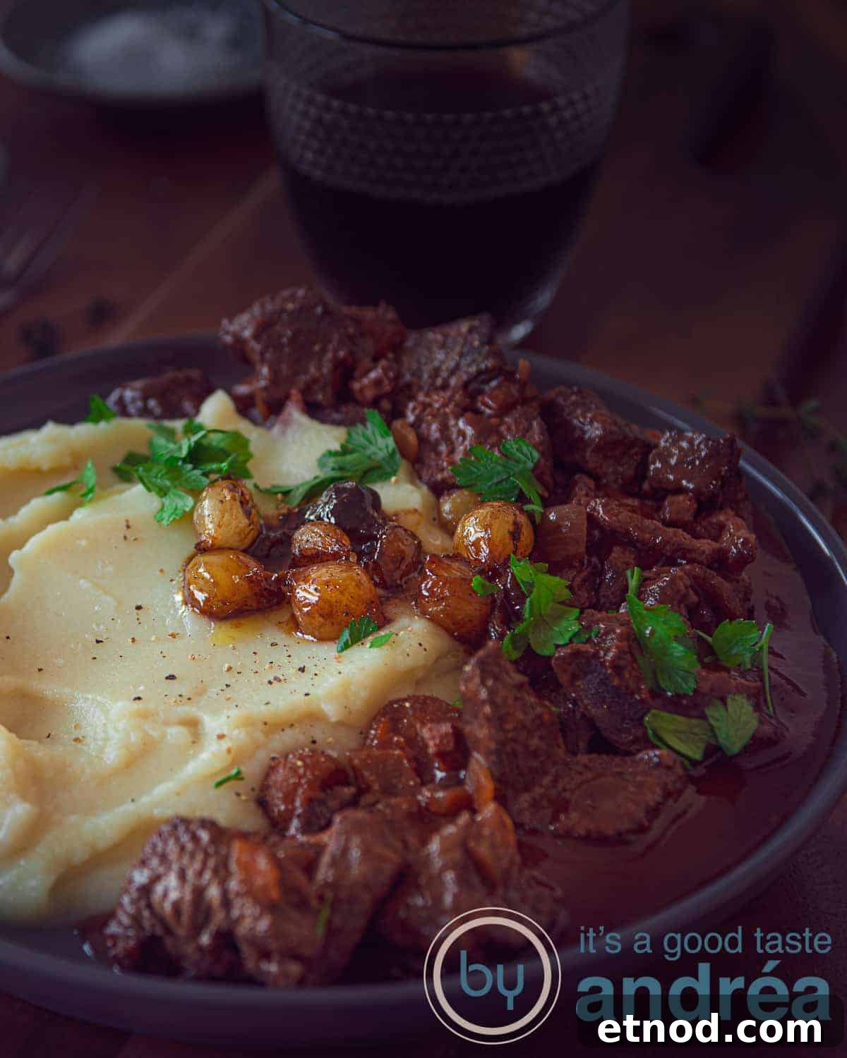 Slow Cooker Beef Bourguignon Without Mushrooms: Tender, Rich Stew 2 A photo with a plate of mashed potatoes, beef bourguignon and caramelized onions on a dark background