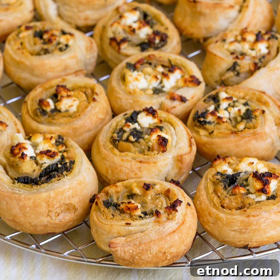 Spinach and Feta Hummus Pinwheels: Party Appetizer 4 Close up of hummus puff pastry pinwheels cooling on a rack.