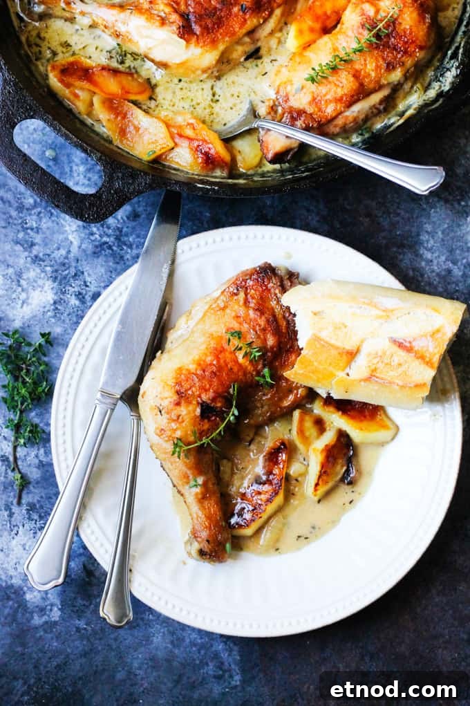 Braised Chicken Normandy with Apple Cider and Brandy 21 Chicken normandy on a white plate with skillet in the back