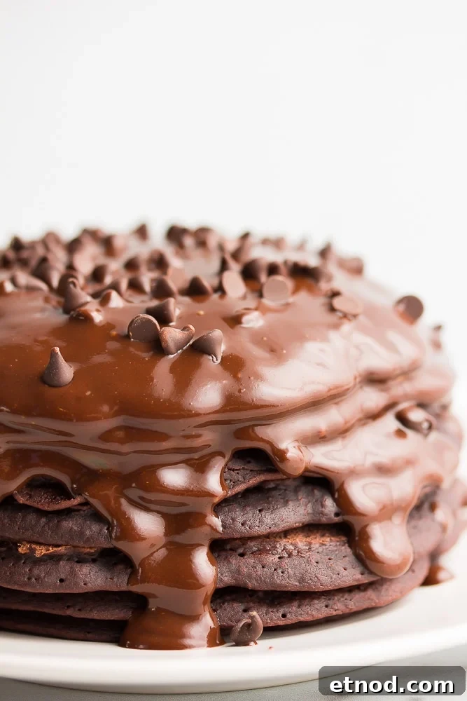 Fluffy Vegan Chocolate Pancakes Recipe for Rich, Dairy-Free Indulgence 2 stack of chocolate pancakes with ganache and chocolate chips