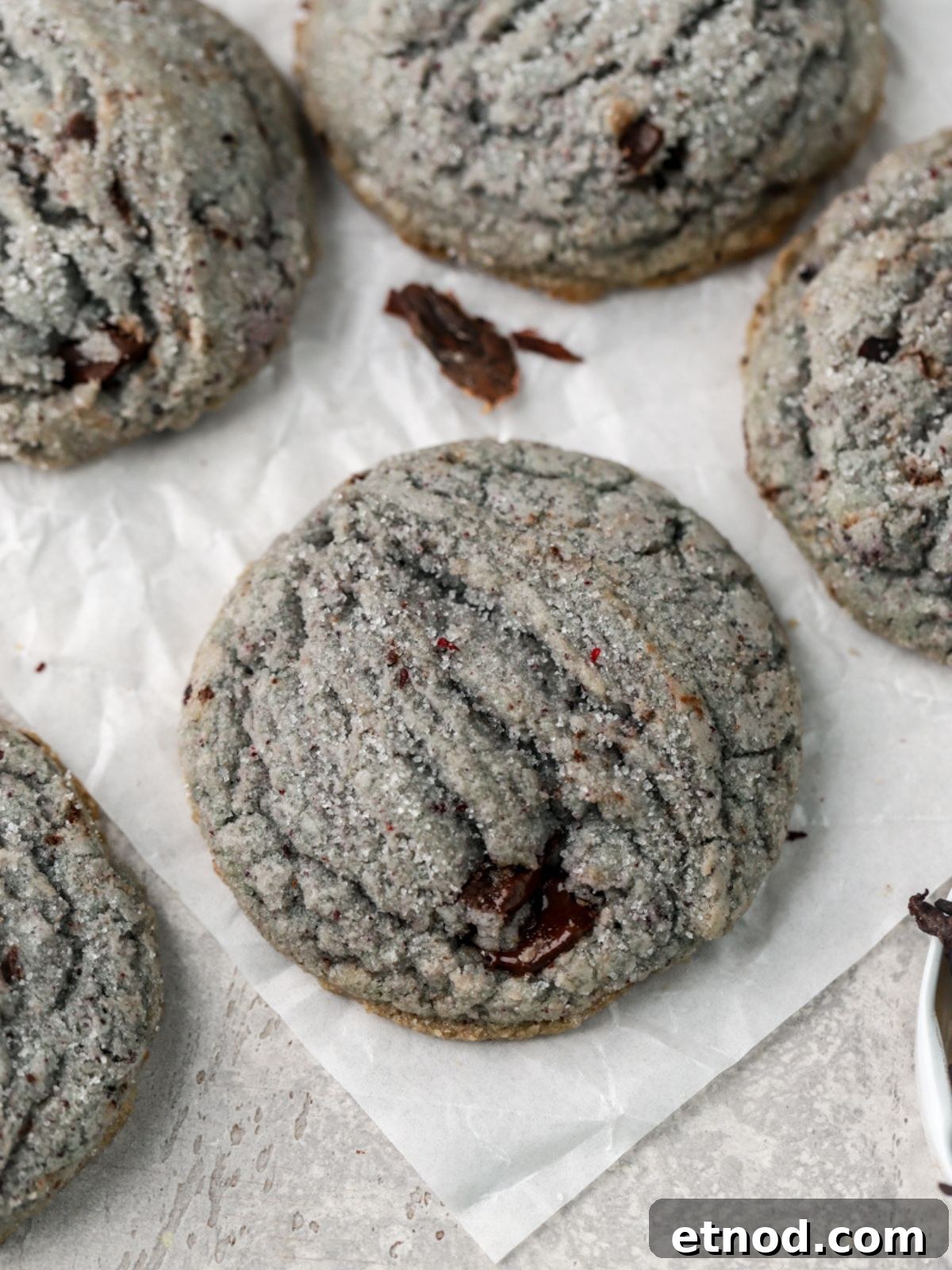 Hibiscus-Infused Sugar Cookies Recipe for Floral Cookies 7 Sugar coated cookies and some dried hibiscus on parchment paper.
