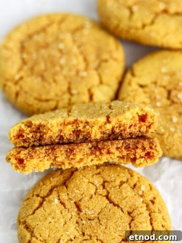 Golden turmeric cookies split in half on parchment paper.