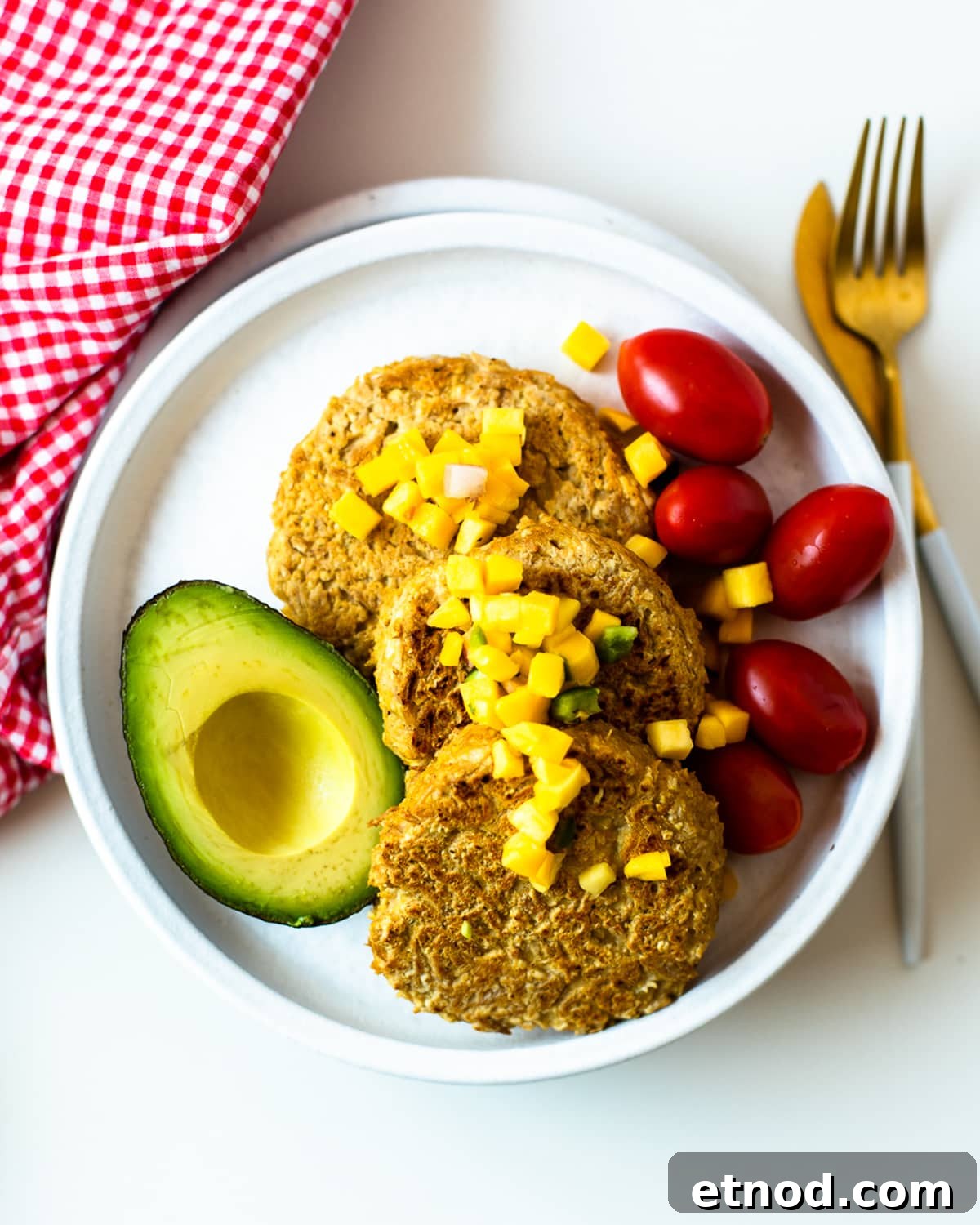 Healthy tuna patties made with canned tuna and oat flour, topped with mango salsa and served with fresh avocado.