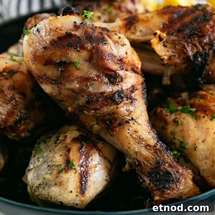 A close up image of a drumstick within the pile of grilled drumsticks.