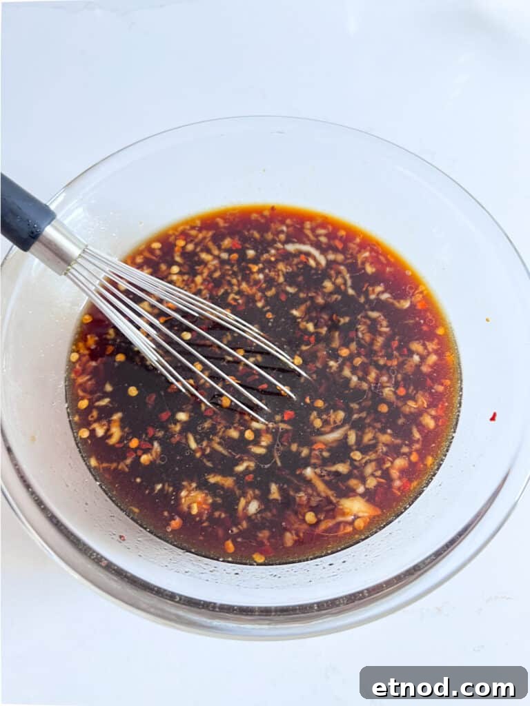 Hawaiian Aloha Chicken Recipe with Pineapple and Teriyaki Glaze 5 Marinade in a bowl with a whisk in it.
