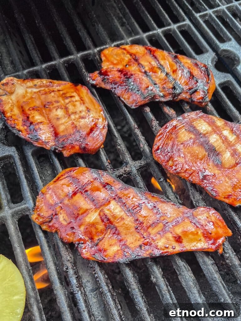 Hawaiian Aloha Chicken Recipe with Pineapple and Teriyaki Glaze 7 Chicken cooking on a grill.