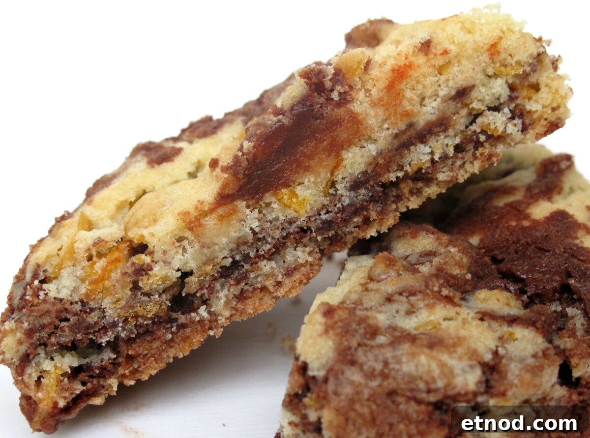 Special Order Cereal Cookies- Captain Crunch? Frosted Flakes? Cocoa Puffs? Customize these cookies with your favorite breakfast cereal! | The Monday Box Chocolate-vanilla cookie cut in half showing interior marbled crumb.