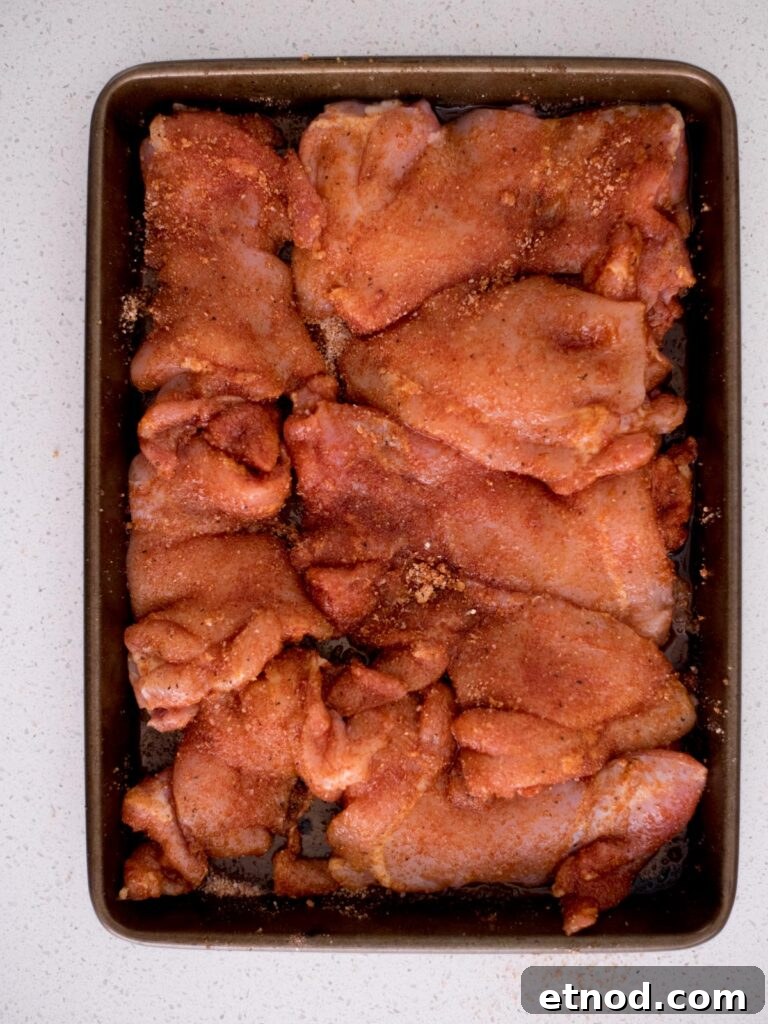 Juicy Chicken Thighs on a Pellet Grill: Flavorful Recipe Guide 5 Baking sheet covered with seasoned raw chicken thighs.