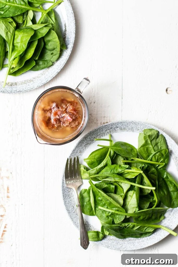 Warm Bacon Vinaigrette Recipe for Salads and Veggies 2 A clear glass dressing pitcher filled with hot bacon dressing.