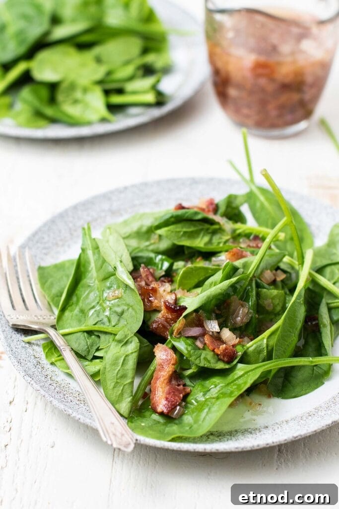 Warm Bacon Vinaigrette Recipe for Salads and Veggies 6 Two plates with spinach salad being topped with hot bacon dressing.
