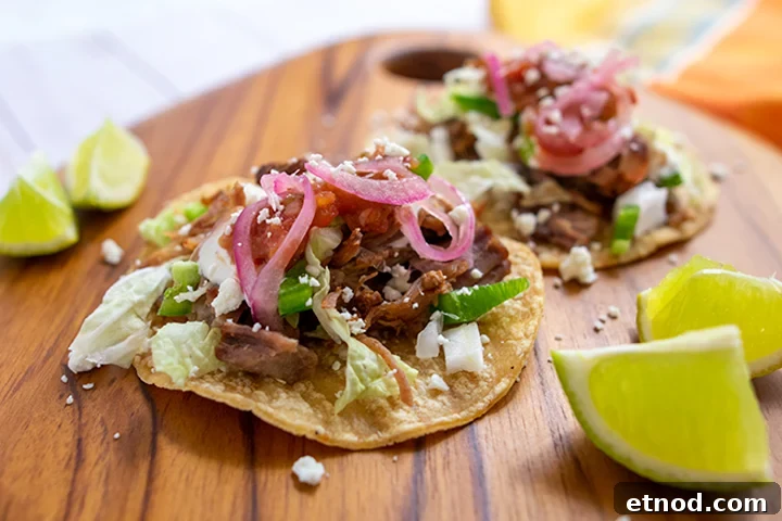 Crispy Instant Pot Carnitas Recipe for Authentic Mexican Flavor 10 2 carnitas tacos on wooden cutting board with limes.