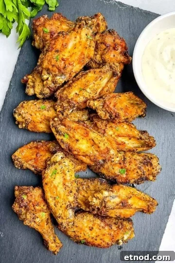 Extra crispy air fryer chicken wings on a serving tray with ranch dipping sauce.