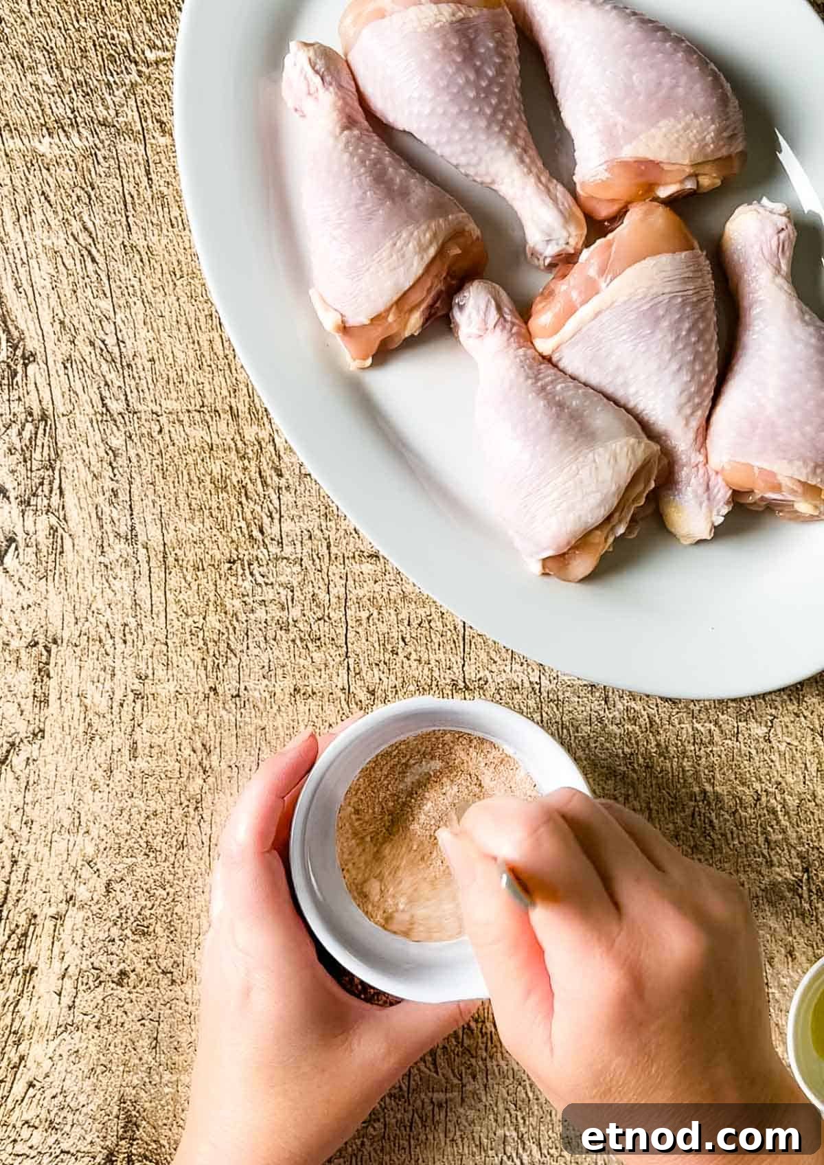 Crispy Air Fryer Chicken Drumsticks — Quick Weeknight Recipe 7 A hand mixing the baking powder and the dry rub together.