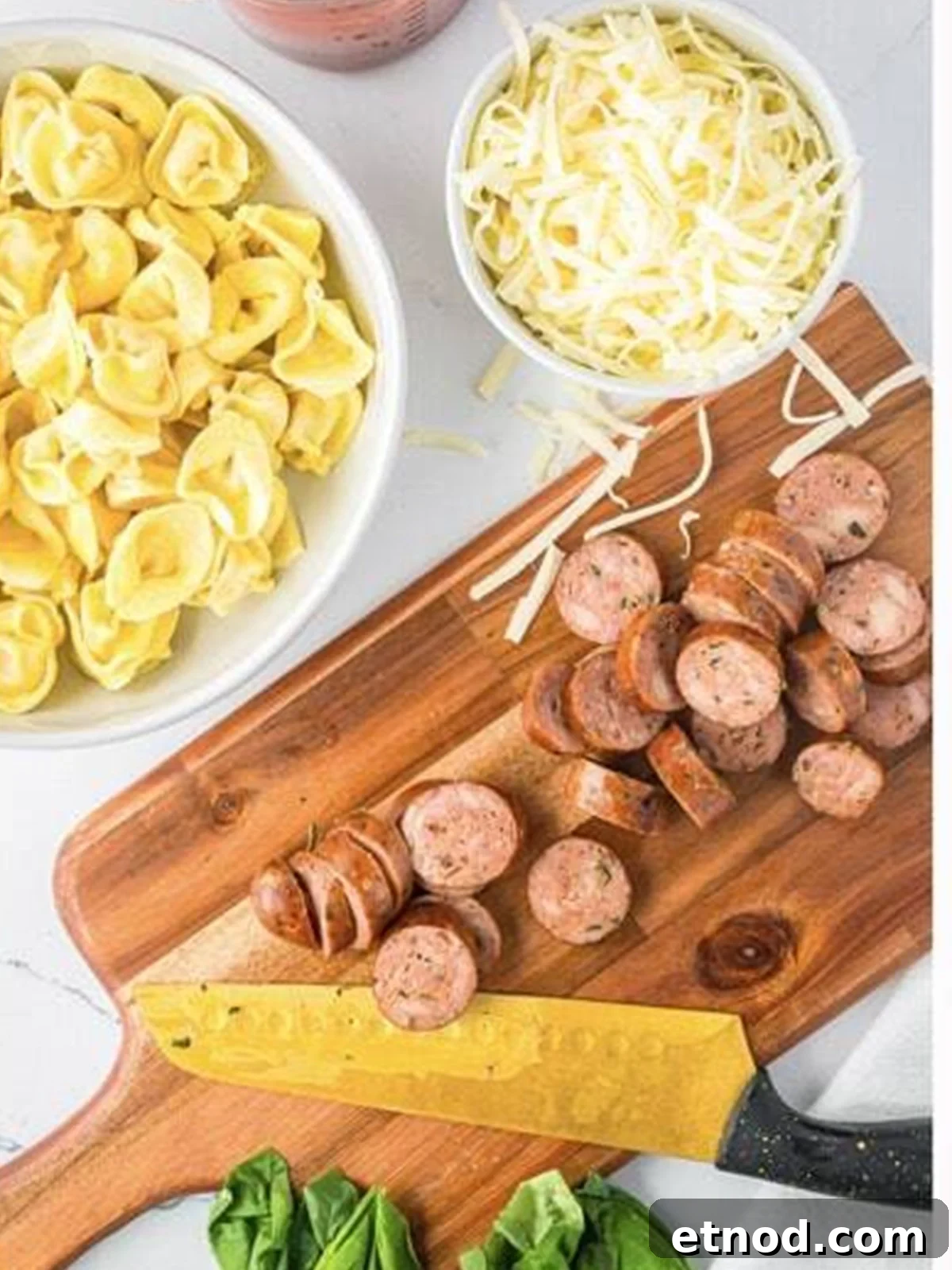 Creamy Italian Sausage Tortellini Bake: Cheesy Oven Pasta Delight 5 Seared Italian sausage sliced into rounds on a cutting board for sausage tortellini bake.