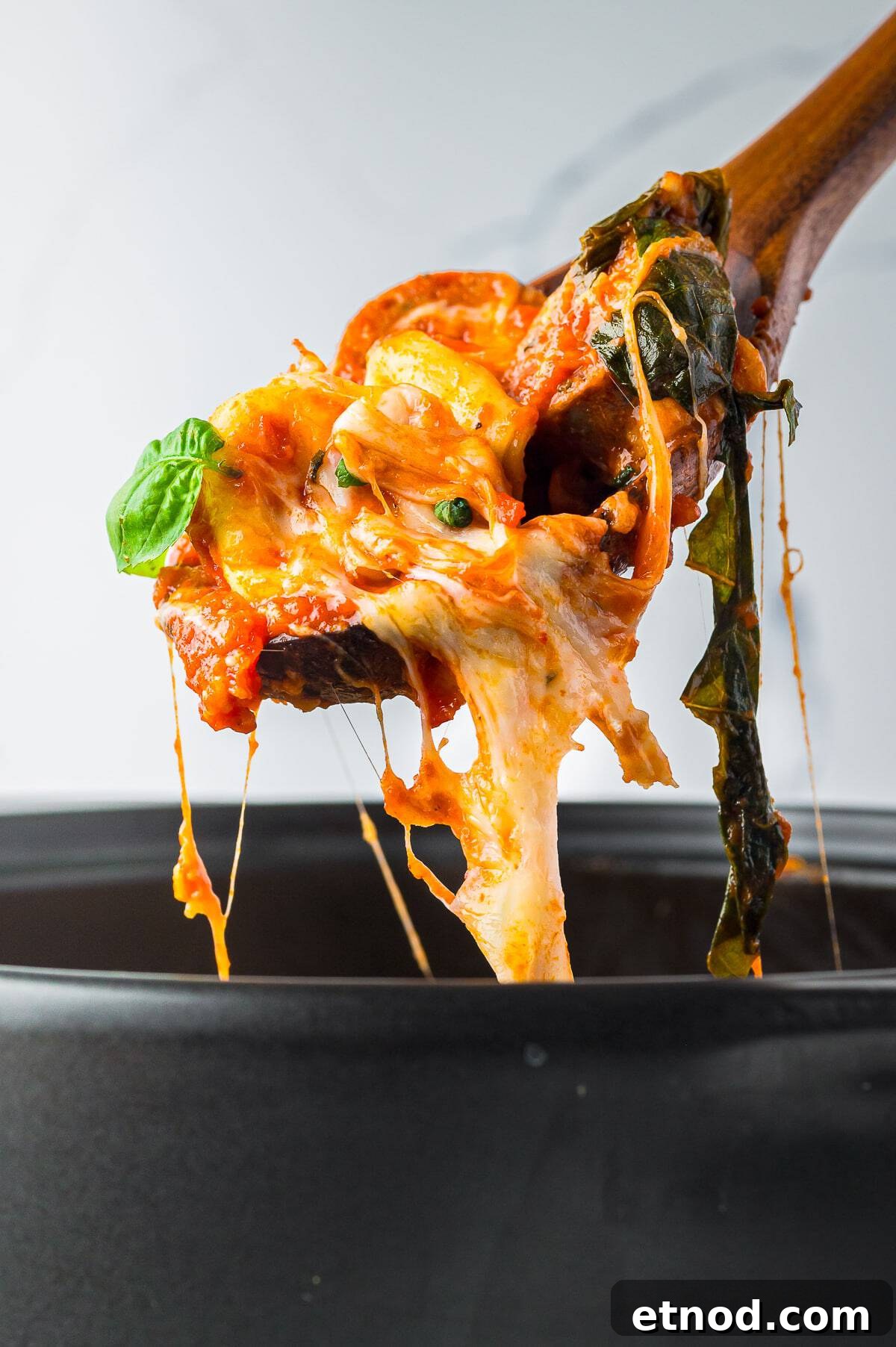 Creamy Italian Sausage Tortellini Bake: Cheesy Oven Pasta Delight 10 Cheese pull from a skillet of sausage tortellini bake showing the melted mozzarella.