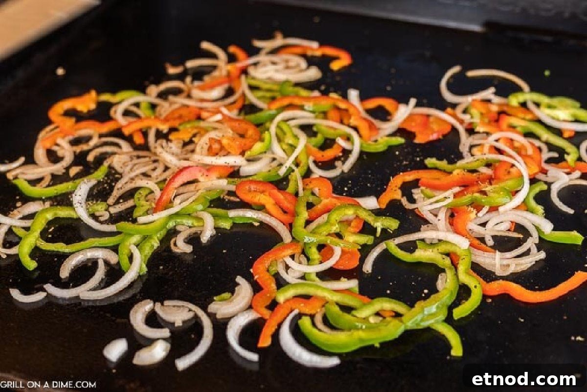 Blackstone Philly Cheesesteak Chicken Sandwich Recipe 4 Cooking vegetables on the griddle.