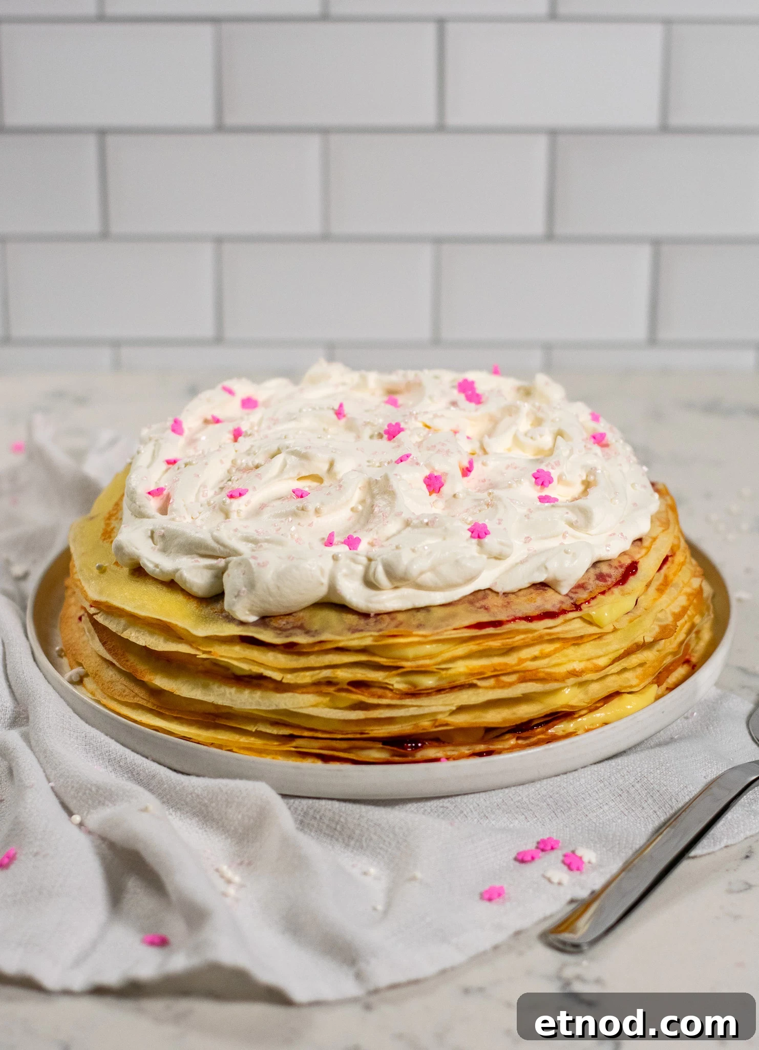 Vanilla and Raspberry Pancake Layer Cake Recipe 2 A pancake layer cake with vanilla pastry cream and raspberry jam, topped with whipped cream.