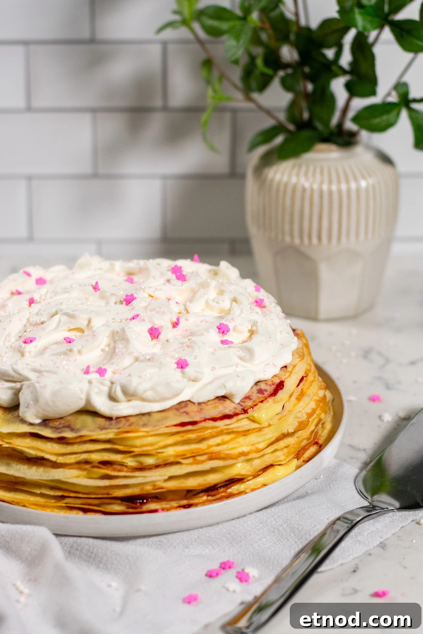 Vanilla and Raspberry Pancake Layer Cake Recipe 3 A pancake layer cake with vanilla pastry cream and raspberry jam, topped with whipped cream.