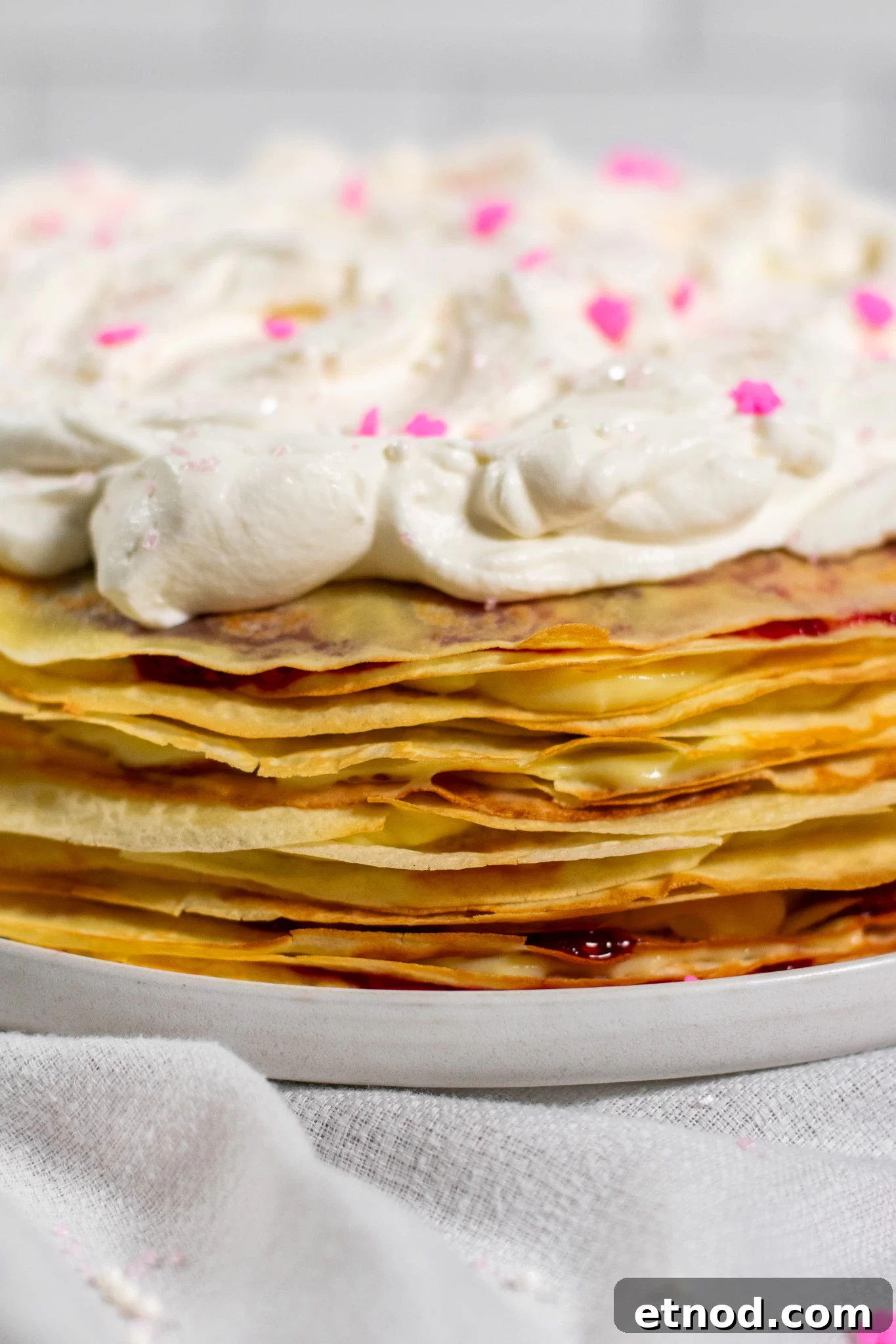 Vanilla and Raspberry Pancake Layer Cake Recipe 5 A pancake layer cake with vanilla pastry cream and raspberry jam, topped with whipped cream.