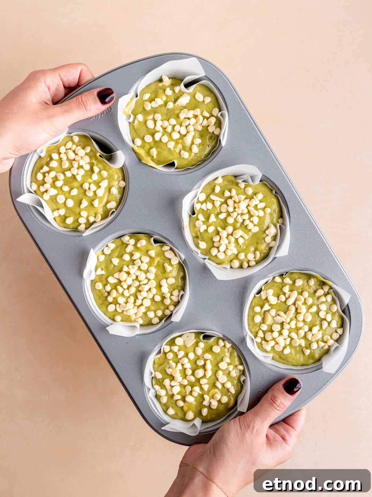 Matcha Muffins with White Chocolate Chips: Soft & Moist Recipe 7 A jumbo muffin pan filled with matcha batter topped with mini white chocolate chips.