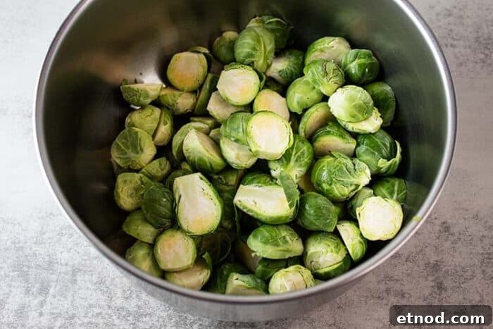 Oven-Roasted Keto Brussels Sprouts Recipe 3 overhead view of metal mixing bowl with chopped and cleaned brussel sprouts