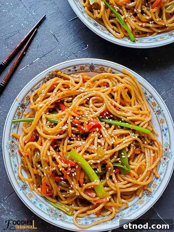 Chili garlic noodles instant pot on a white plate with chopsticks beside