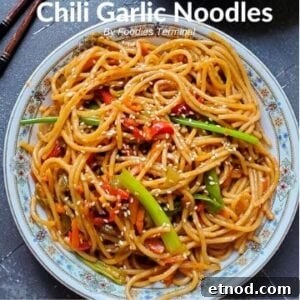 Chili Garlic Noodles garnished with white sesame seeds & served in a white plate