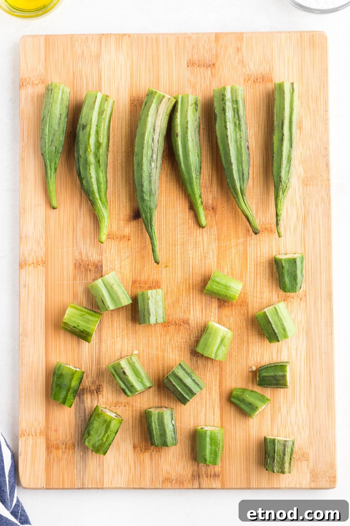 Crispy Air-Fried Okra Recipe for Perfectly Tender Bites 4 Fresh uncooked okra on a wooden cutting board with stems cut and removed.