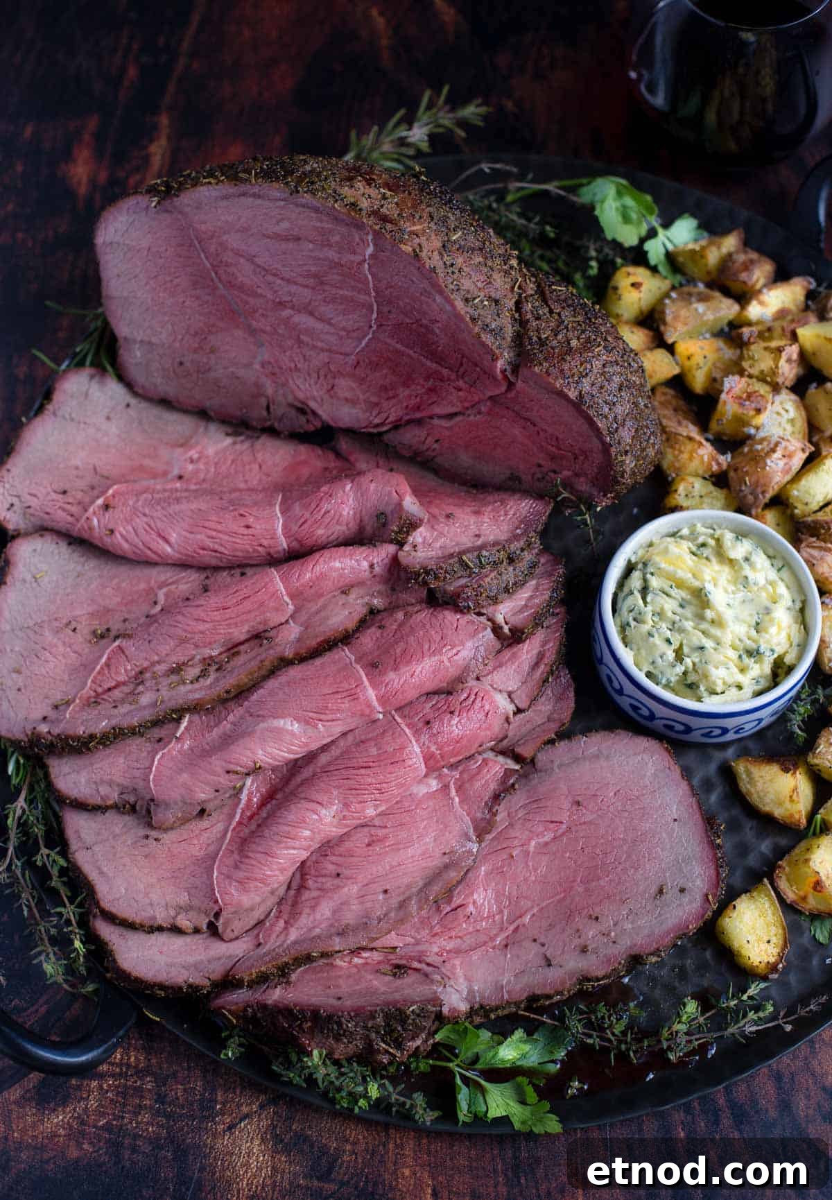 Smoked Herb-Crusted Roast Beef Recipe 2 Top Sirloin Smoked Roast Beef on a platter with potatoes.
