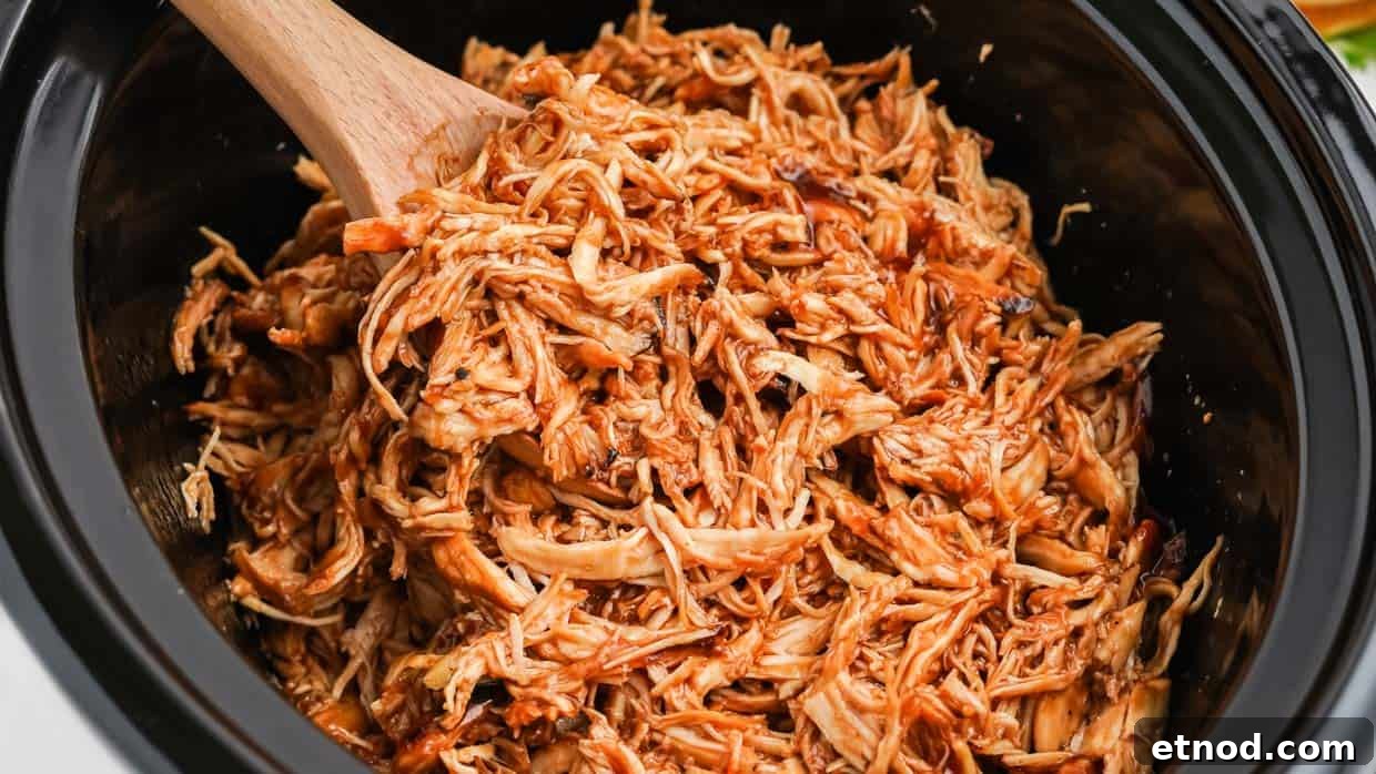 31 Forgotten Grandma Potluck Recipes Worth Bringing Back 25 Slow cooker chicken with BBQ sauce in a crock pot with a spoon.