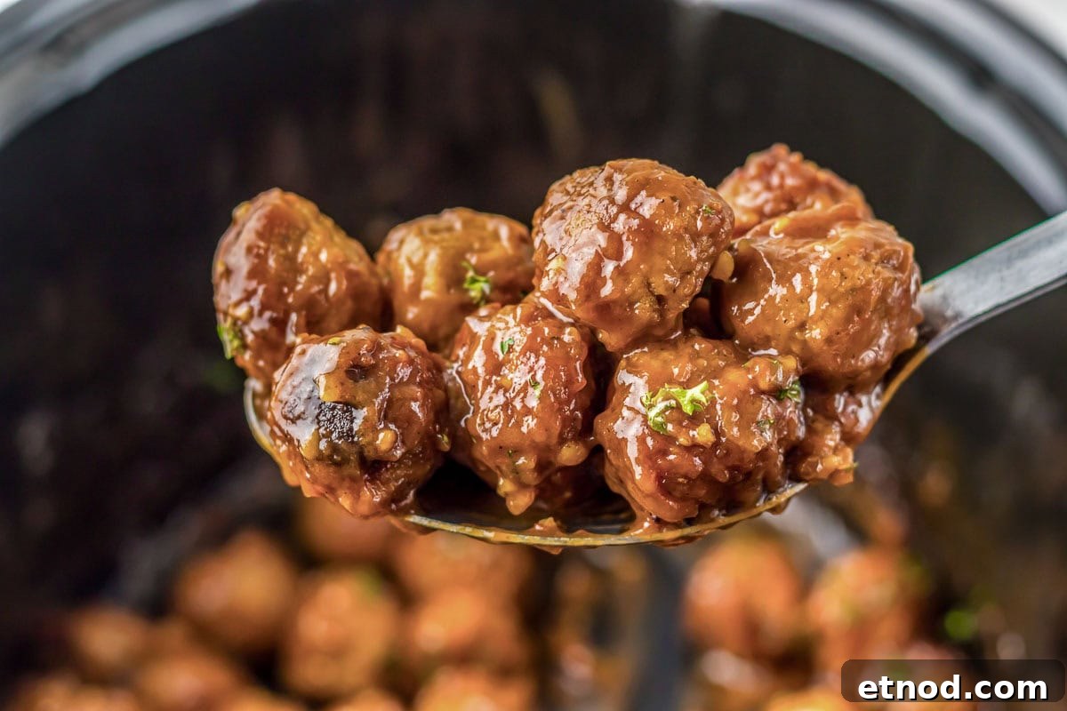 31 Forgotten Grandma Potluck Recipes Worth Bringing Back 27 A spoon holds saucy, glazed meatballs garnished with herbs over a pot with more meatballs inside.