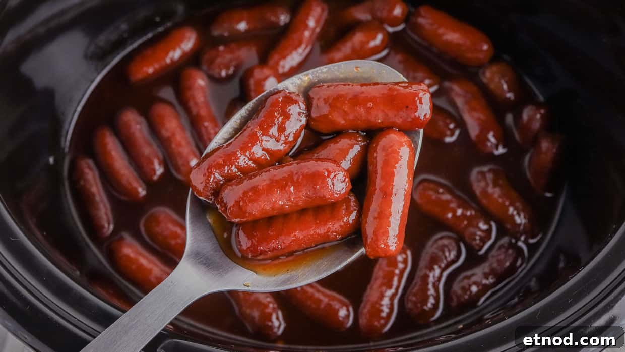 31 Forgotten Grandma Potluck Recipes Worth Bringing Back 4 Crock pot little smokies on a spoon over the slow cooker.