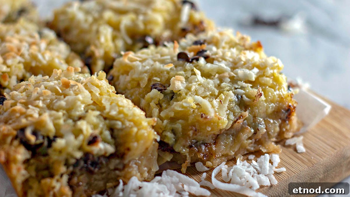 31 Forgotten Grandma Potluck Recipes Worth Bringing Back 32 Gooey coconut bars on a wooden cutting board with coconut.