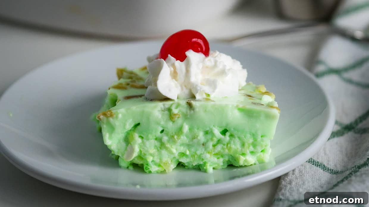 31 Forgotten Grandma Potluck Recipes Worth Bringing Back 7 Piece of lime jello salad topped with whipped cream and a cherry.