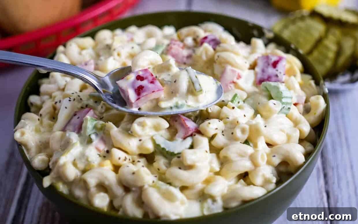 31 Forgotten Grandma Potluck Recipes Worth Bringing Back 8 Bowl of Amish macaroni salad with some on a spoon.