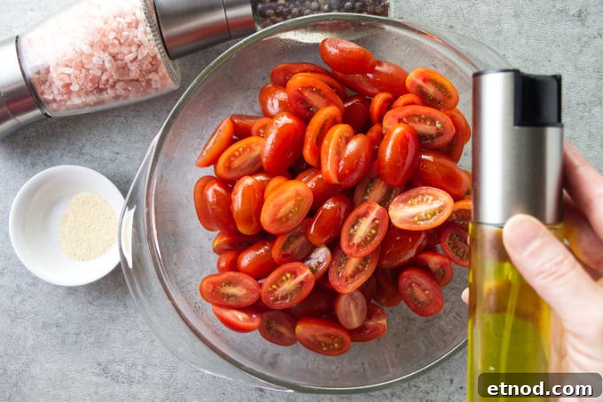 Crispy Air Fryer Cherry Tomatoes Recipe in Minutes 5 Tossing cherry tomatoes with oil and seasoning.
