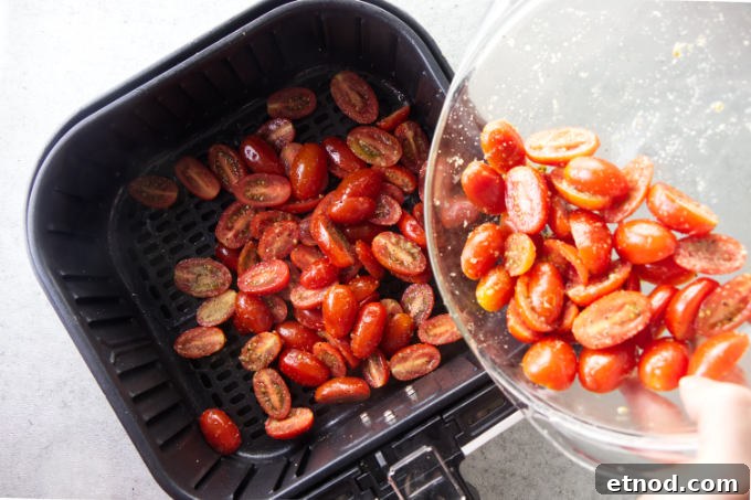 Crispy Air Fryer Cherry Tomatoes Recipe in Minutes 6 Tossing cherry tomatoes in an air fryer basket.