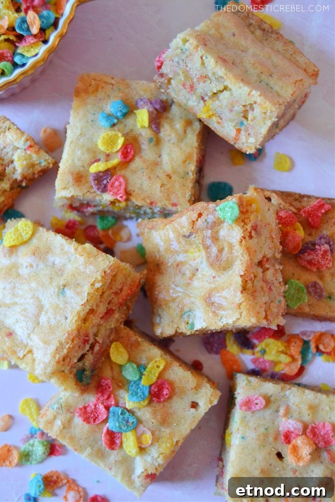 An arrangement of fruity pebble blondies with pieces of cereal