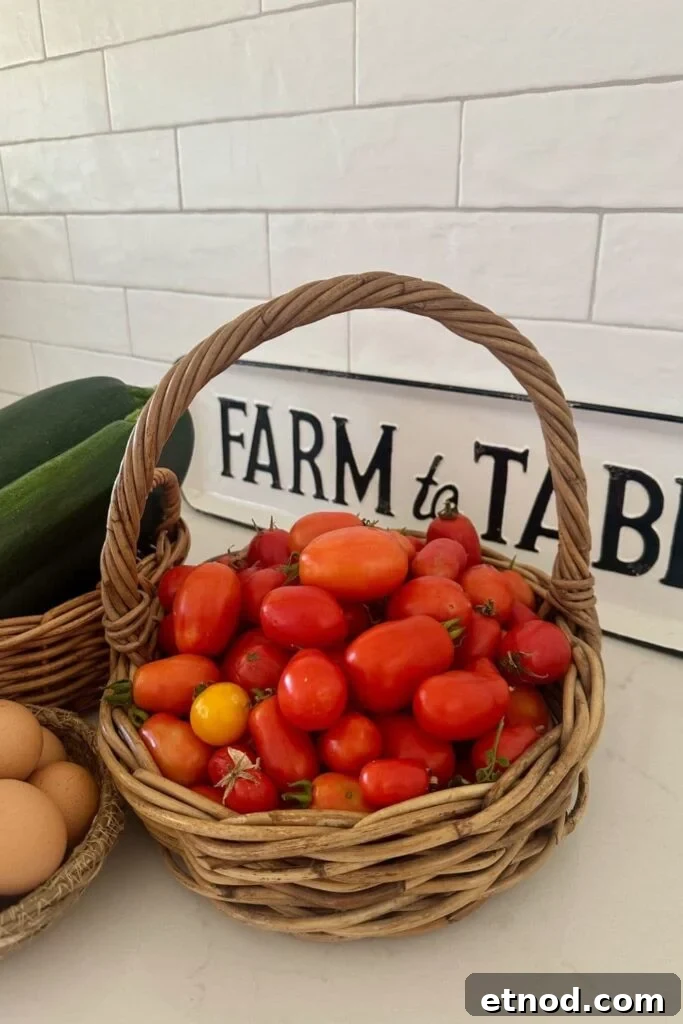 Authentic Homemade Pizza Sauce Recipe for Restaurant-Style Flavor 4 A cane basket filled with red roma tomatoes. You can see a sign that says "Farm to Table" in the background, as well as a basket of zucchinis and eggs.